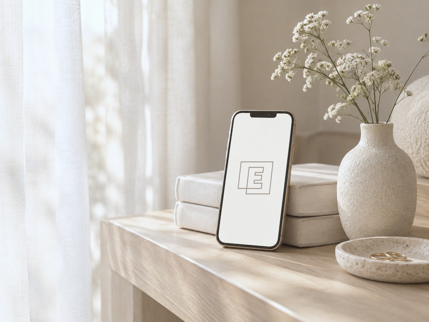 Telefon z aplikacjami Elory na półce obok wazonu z kwiatami